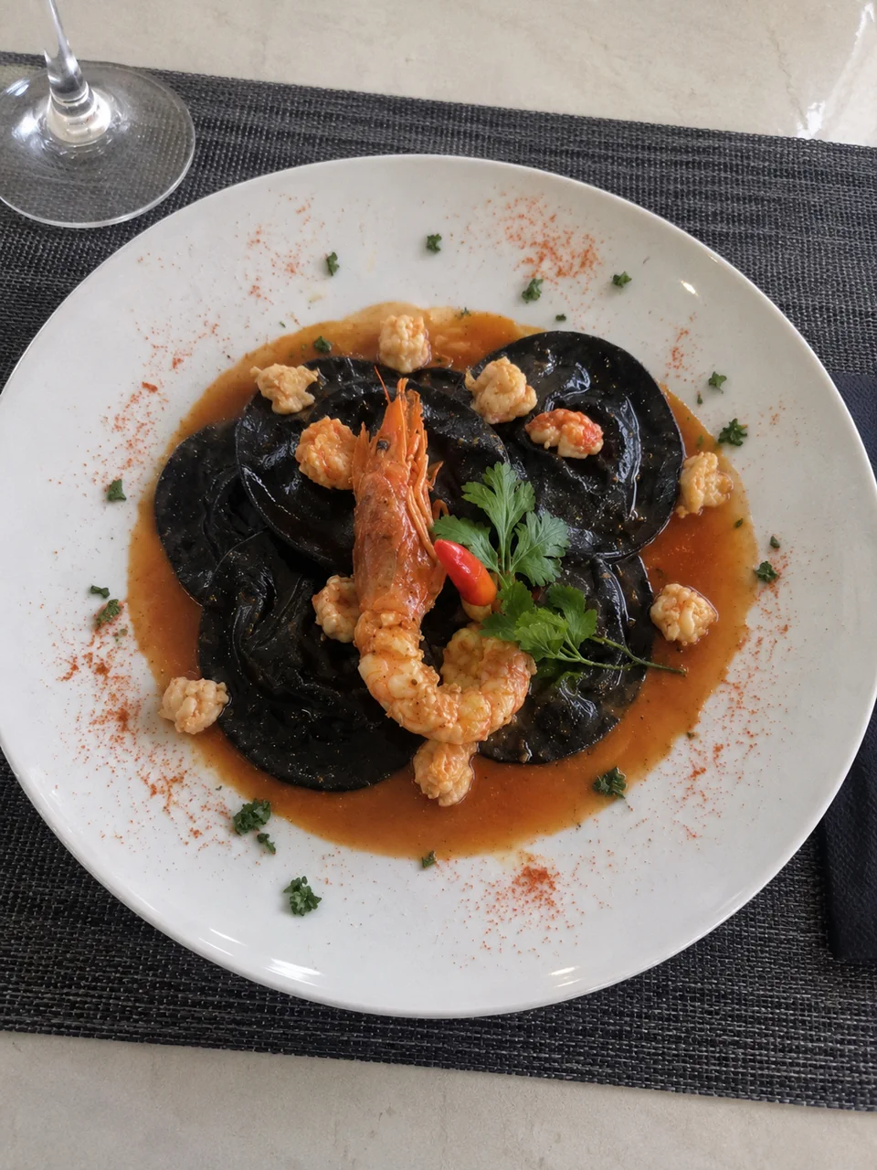 Ravioli negros de marisco en salsa ligera de Lungomare